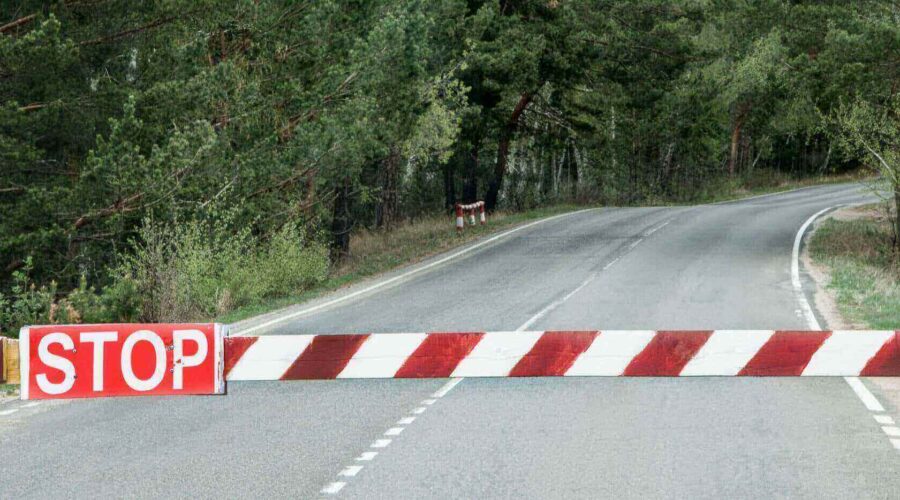 Roadblock with a red and white barrier featuring a 'STOP' sign-Web filter