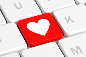 Close-up of a computer keyboard with a red key featuring a white heart symbol-computer cleaning solution