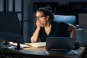 woman sitting at a desk with shocked expression- colonial pipeline cyber attack