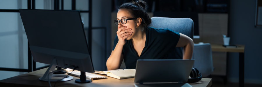 woman sitting at a desk with shocked expression- colonial pipeline cyber attack